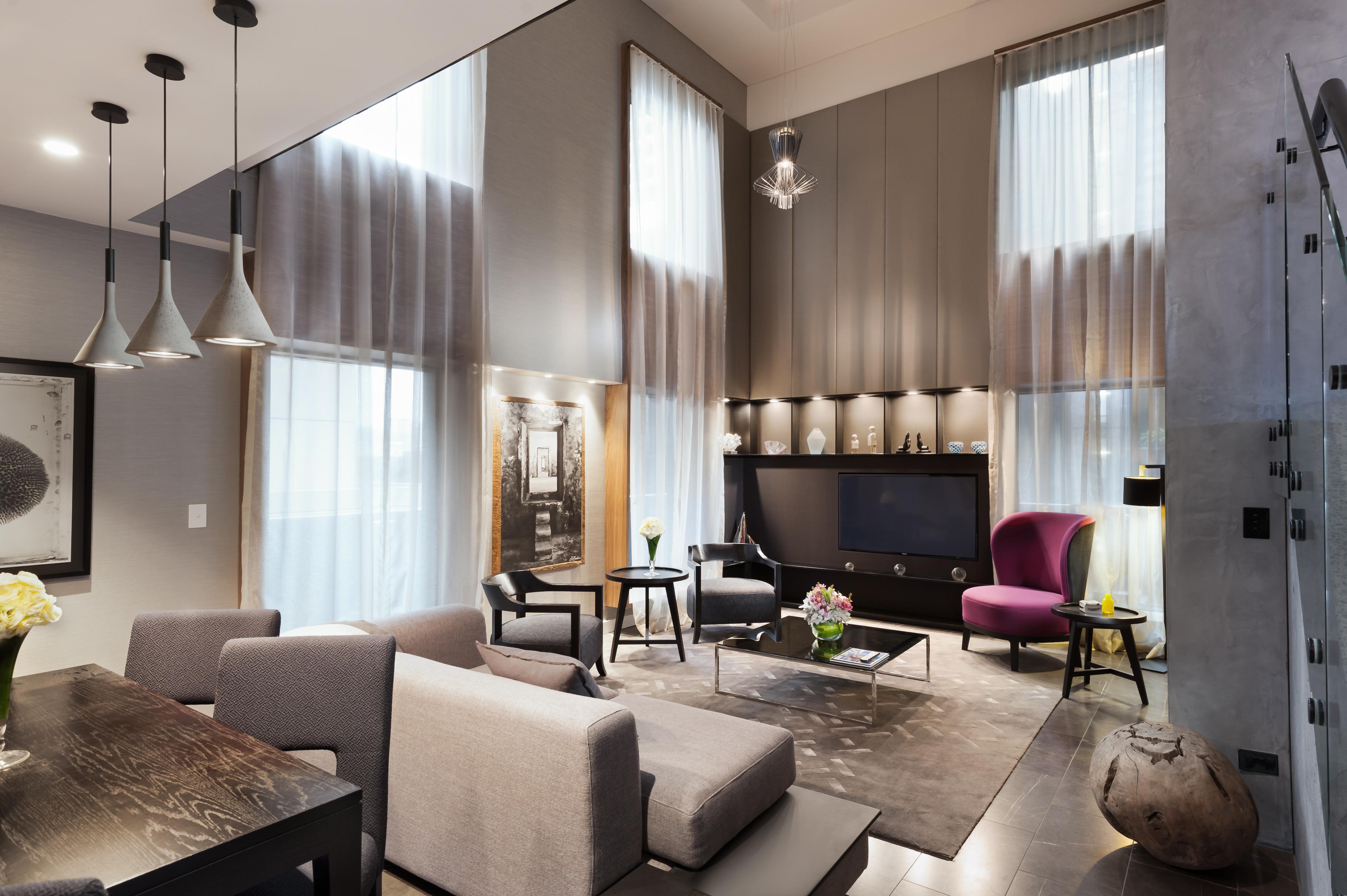Hotel Stamford Plaza Melbourne Zewnętrze zdjęcie The photo shows a stylish and modern living room with high ceilings and large windows that allow natural light to brighten the space. The room features a mix of contemporary furniture, including a light gray sofa and a sleek coffee table in the cente